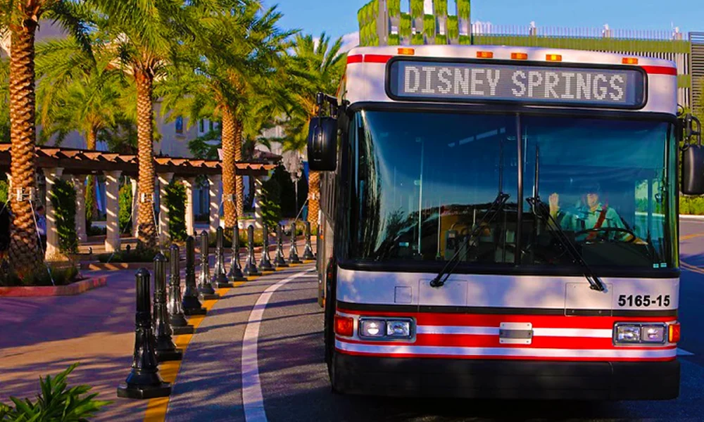 Disney volta a exigir reservas para embarque nos ônibus de Disney Springs para hotéis. Veja quem poderá utilizar o transporte. Ônibus da Disney em Disney Springs realizando transporte para hotéis Disney