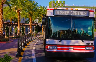 Disney volta a exigir reservas para embarque nos ônibus de Disney Springs para hotéis. Veja quem poderá utilizar o transporte. Ônibus da Disney em Disney Springs realizando transporte para hotéis Disney