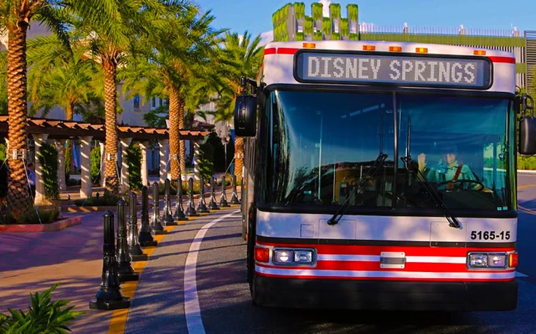 Disney volta a exigir reservas para embarque nos ônibus de Disney Springs para hotéis. Veja quem poderá utilizar o transporte. Ônibus da Disney em Disney Springs realizando transporte para hotéis Disney